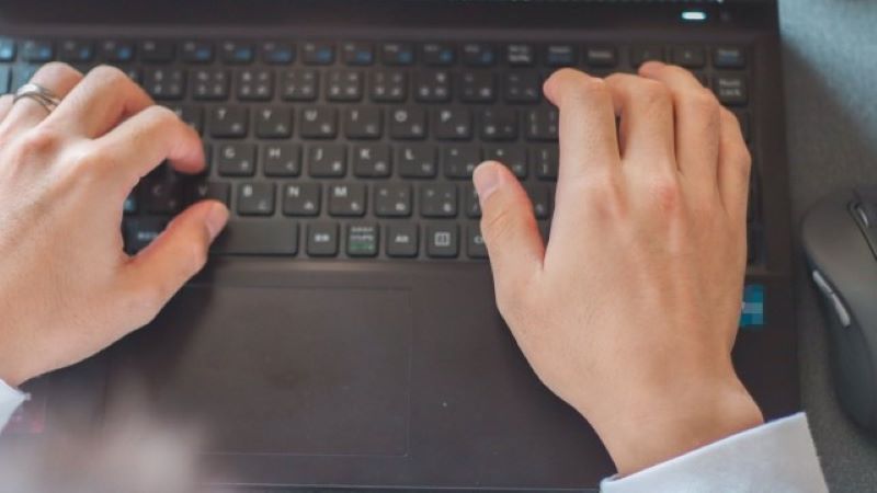 内部SEO対策(オンページSEO)の実施風景。ノートパソコンのキーボードで記事制作や設定変更を行う様子。