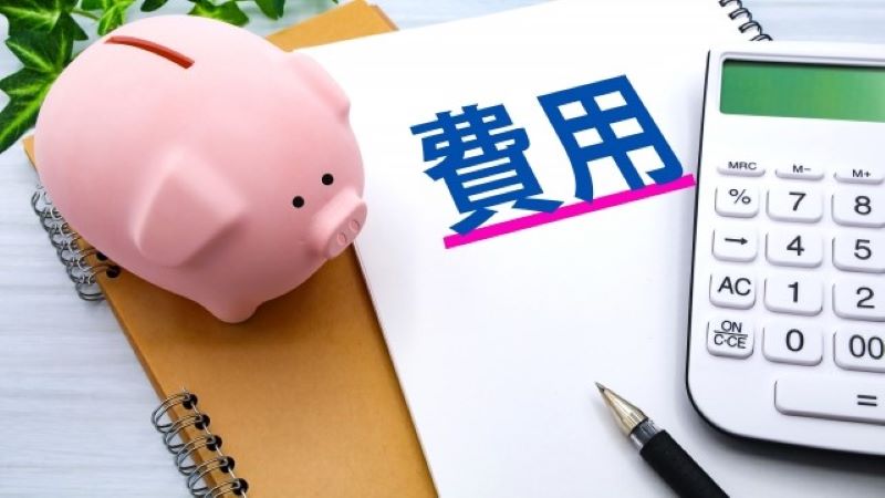 SEO対策を依頼する際のコストや費用感をイメージ。貯金箱と電卓で予算管理の重要性を表現。