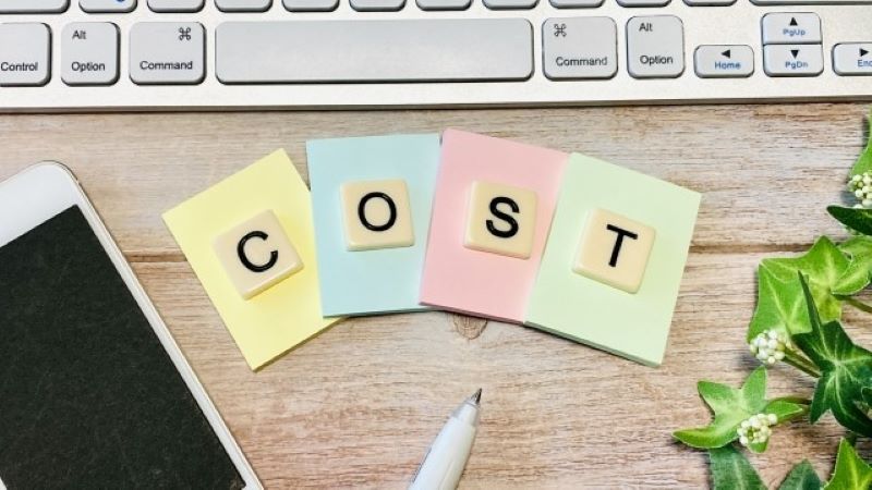 SEO対策を依頼する費用相場とコストパフォーマンス。キーボードの手前に並ぶ「COST」と書かれた4色のカード。
