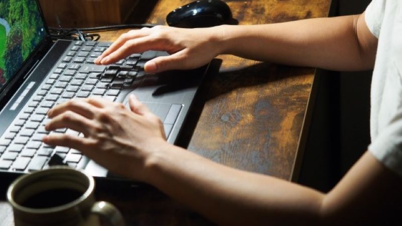 SEO対策の依頼で注意すべき悪質業者の特徴を確認しながら、PCで情報を精査する様子のイメージ。