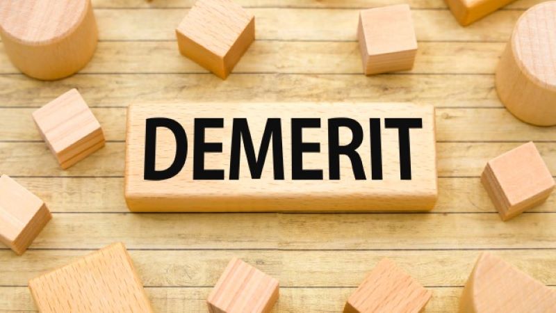 オウンドメディア集客におけるデメリットや注意点を解説する、DEMERIT(デメリット)と刻印されたウッドブロック。